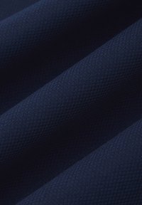 Granatowa, teksturowana tkanina z diagonalnym wzorem, ukazująca fałdy, które tworzą głębię. Miękka i gładka powierzchnia z delikatnym połyskiem.