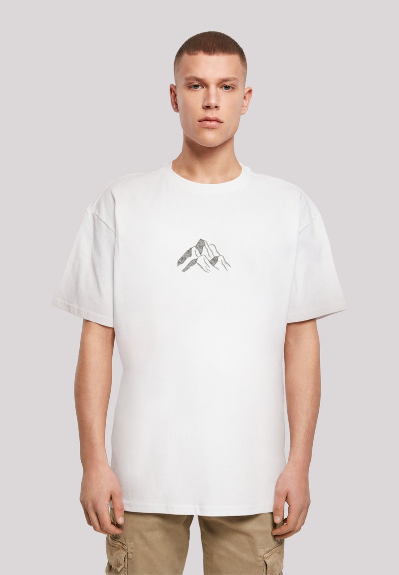 Witte katoenen T-shirt met een losse pasvorm, met een kleine bergafbeelding in het midden. Korte mouwen en een ronde halslijn.