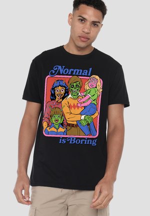 Mann trägt ein schwarzes T-Shirt mit einer bunten Cartoon-Familie aus vier Personen mit grünen Zombie-Gesichtern und dem Satz "Normal ist langweilig."