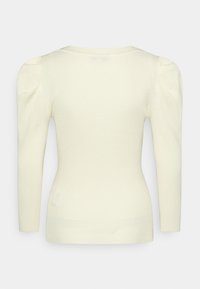 Pull à manches longues côtelé de couleur crème avec de légers épaules bouffantes et une silhouette ajustée, vu de dos.