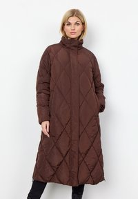 Bruine gewatteerde lange pufferjas met een hoge kraag, diagonale stiksels en ritszakken, gemaakt van een gladde, waterafstotende stof.