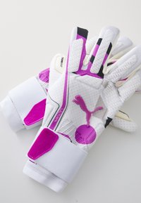 Baltieji vartininko pirštinės su rožiniais akcentais ir tekstūruotu sukibimu. Įeina 'Puma' logotipas ir velcro riešo dirželiai su 'Ultra' ženklu.