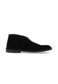Bottines en daim noir avec un extérieur lisse, des accents cousus et une semelle en caoutchouc basse et plate. Design minimaliste sans quincaillerie visible.