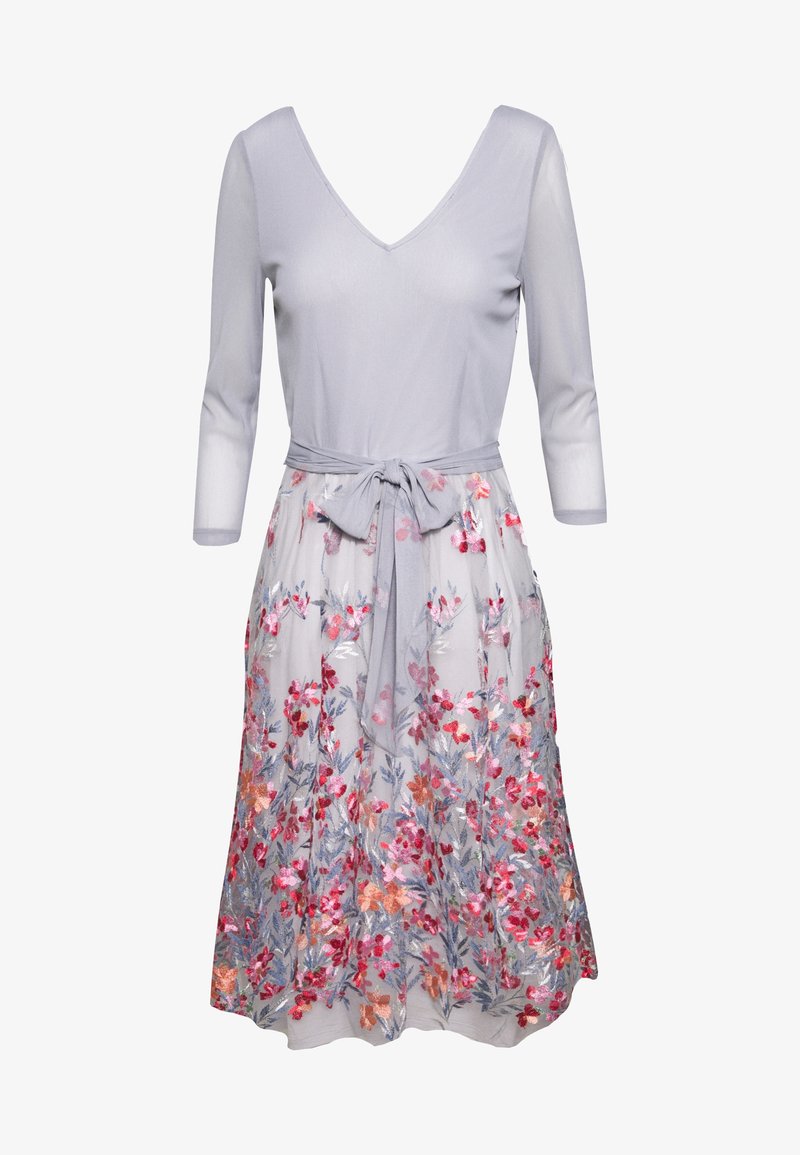 Robe violette claire avec manches trois-quarts, col en V et jupe brodée de fleurs, attachée à la taille par une ceinture en tissu assorti.