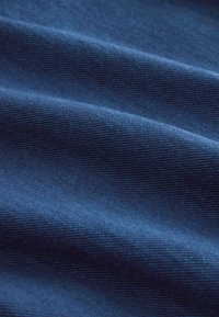 Navy blue fabric with a slightly textured surface, featuring subtle ribbed patterns and folds, highlighting its smooth and soft appearance.