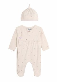 Une barboteuse beige clair avec des manches longues, ornée de petits motifs de cœurs multicolores et d'un bonnet assorti avec un nœud sur le dessus.