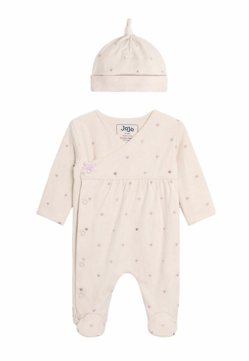 Une barboteuse beige clair avec des manches longues, ornée de petits motifs de cœurs multicolores et d'un bonnet assorti avec un nœud sur le dessus.