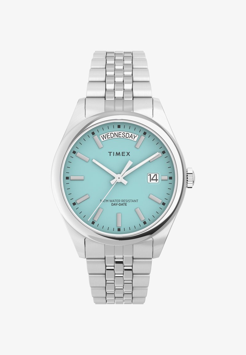 Orologio Timex con quadrante azzurro chiaro, cassa e bracciale in acciaio inox argentato. Presenta un display del giorno e della data, lancette luminose e resistenza all'acqua.