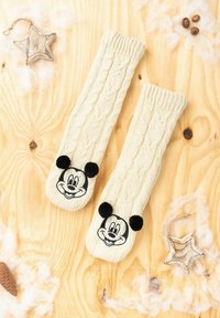 Calzini lavorati a maglia color crema con motivo a treccia, con il volto di Topolino nero e dettagli in pom-pom sulla punta.