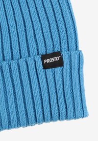 Niebieska dziana czapka z prążkowaną fakturą. Na mankiecie znajduje się czarna metka z logo "PROSTO". Wykonana z miękkiej, elastycznej przędzy.