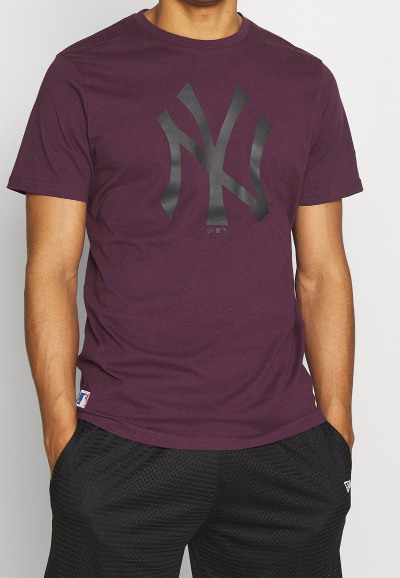 Mörkröd t-shirt med en svart New York Yankees-logotyp, korta ärmar, rund hals, tillverkad av mjukt tyg, kombinerad med svarta mesh-shorts.
