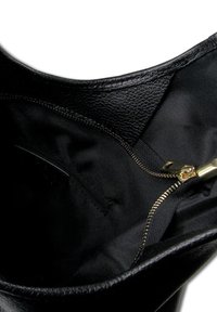 Zwarte leren handtas interieur met een ritsvak en een gladde stofvoering. Gouden ritshardware zichtbaar.