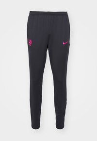 Schwarze Sporthosen mit schlankem Schnitt, versehen mit einem pinkfarbenen Nike-Logo und Wappen-Design. Hergestellt aus einem glatten, elastischen Material.