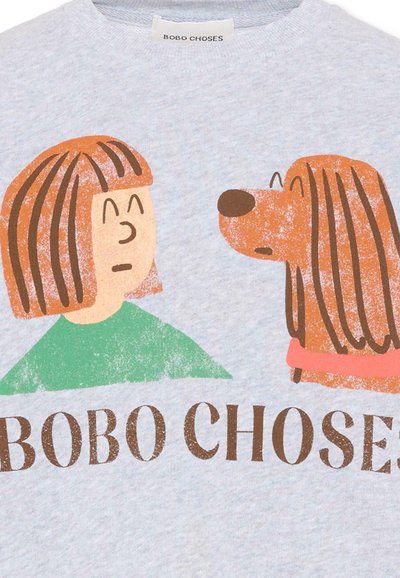 Illustration d'une personne aux cheveux bruns portant un t-shirt vert, faisant face à un chien brun à poils longs avec un collier rose, avec au-dessus le texte "BOBO CHOSES."