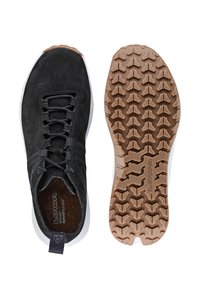 Scarpa sportiva nera in suede con chiusura a lacci, superficie testurizzata, suola intermedia bianca a contrasto e suola in gomma marrone con un motivo di battistrada.