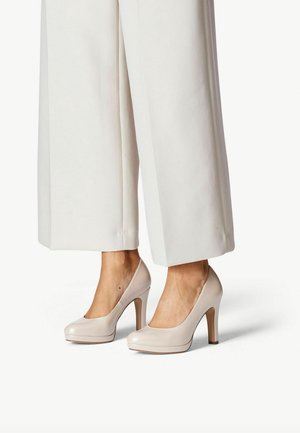 Beige lakleren hoge hakken met ronde neuzen en een blokhak van 10 cm, aangevuld met een subtiele plateauzool en een gladde afwerking.