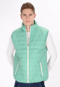 Mintgrüner gepolsterter Weste mit hohem Kragen, ausgestattet mit einem Frontreißverschluss und zwei Reißverschlusstaschen an den Seiten. Glatte Textur und gestepptes Design.