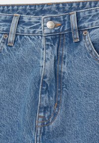 Light blue denim jeans featuring a button closure, five-pocket design, and contrasting orange stitching. Fabric has a classic texture.