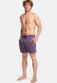 Ανδρικά μωβ μαγιό με κορδόνι στη μέση, πλευρικές τσέπες και ένα μικρό λογότυπο στο κάτω μέρος, κατασκευασμένα από ελαφρύ ύφασμα.