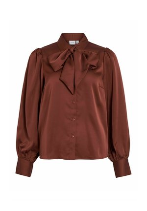 Brūna satīna blūze ar augstu apkakli, pārspīlētu loksnes aksesuāru pie dekoltē, pogu aizdari un pūkainām garām piedurknēm ar elastīgām aprocēm.