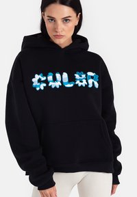 Czarny sweatshirt z kapturem z kolorowym, teksturowanym napisem "KOLOR" w odcieniach niebieskiego i białego, z kieszenią z przodu i luźnym krojem.