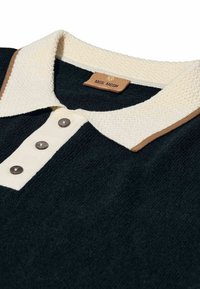 Čierna pletená polokošeľa s textúrovaným krémovým golierom, tromi čiernymi gombíkmi na krémovom pásiku a hnedým lemovaním na okraji goliera.