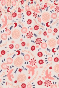 Witte stof met een herhalend patroon van rode en roze bloemen, zonnen, hopen en vogels. Elastische tailleband met een geplooide textuur.