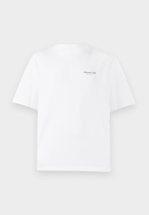 T-shirt bianco in cotone con colletto rotondo, maniche corte e un piccolo logo nero sul lato superiore sinistro del petto. Texture liscia.