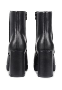 Black leather ankle boots with a smooth texture, featuring a square heel and side zippers for easy wear. Clean lines and minimalist design.