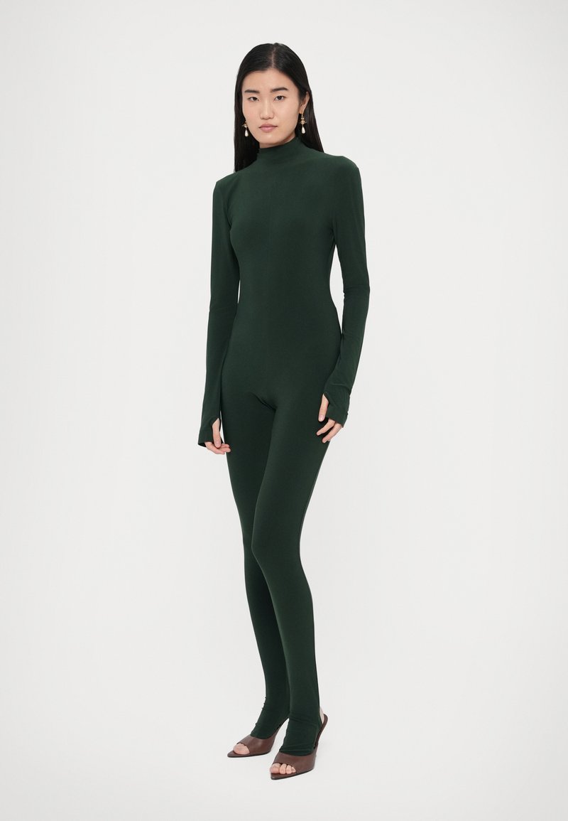 Body verde scuro con collo alto, maniche lunghe e aperture per le mani. Realizzato in tessuto liscio ed elastico, design aderente, copertura completa.