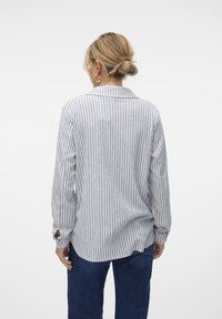 Gestreept overhemd met knopen in lichtblauw en wit, met lange mouwen, een kraag en een ontspannen pasvorm met zijinkepingen voor bewegingsvrijheid.
