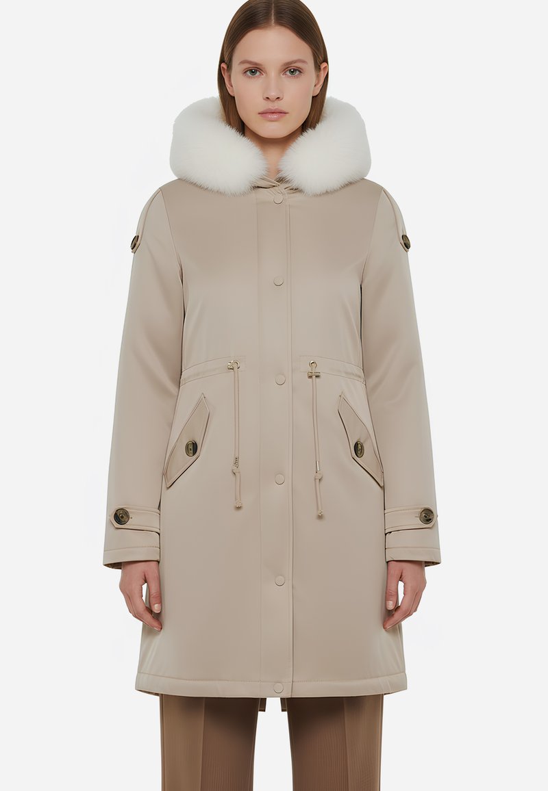 Parka beige con cappuccio foderato in bianco, vita regolabile con cordoncino, due tasche frontali e bottoni decorativi. Texture liscia con un design elegante.