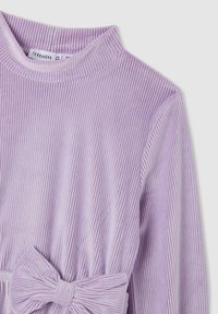 Fioletowa bluzka z długim rękawem, wykonana z prążkowanej tkaniny, z wysokim kołnierzem i detalem w postaci kokardy w talii, co dodaje tekstury i stylu.