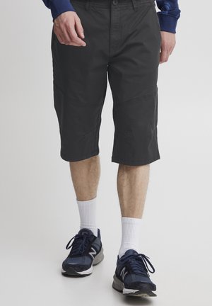 Svart cargo shorts med knelengde design. Laget av lettvektig stoff, med side lommer og sydd paneldetaljering.