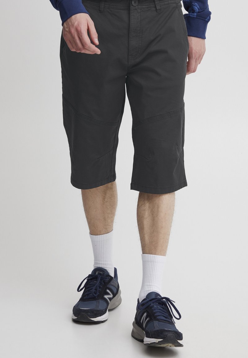 Shorts cargo negri cu un design până la genunchi. Fabricate dintr-un material ușor, dotate cu buzunare laterale și detalii cusute pe panouri.