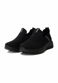 Zapatillas negras tipo slip-on con parte superior de punto texturizado y suela de goma. Presentan tiradores en el talón y un logotipo mínimo en los laterales.