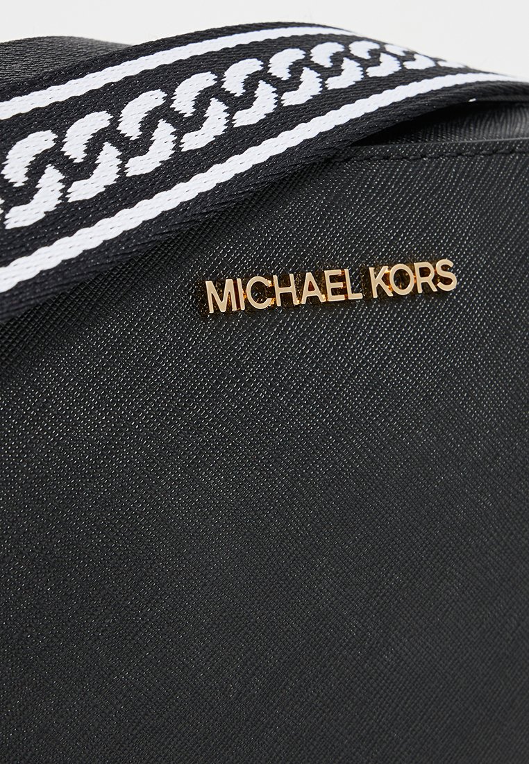 Czarna torebka o teksturowej powierzchni, z złotym logo "Michael Kors" i wzorzystym czarno-białym paskiem.