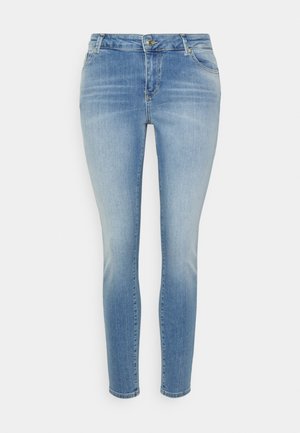 Jeans skinny em azul claro feitos de denim. Apresenta um design clássico de cinco bolsos, fecho de botão e leve desbotamento nas coxas.