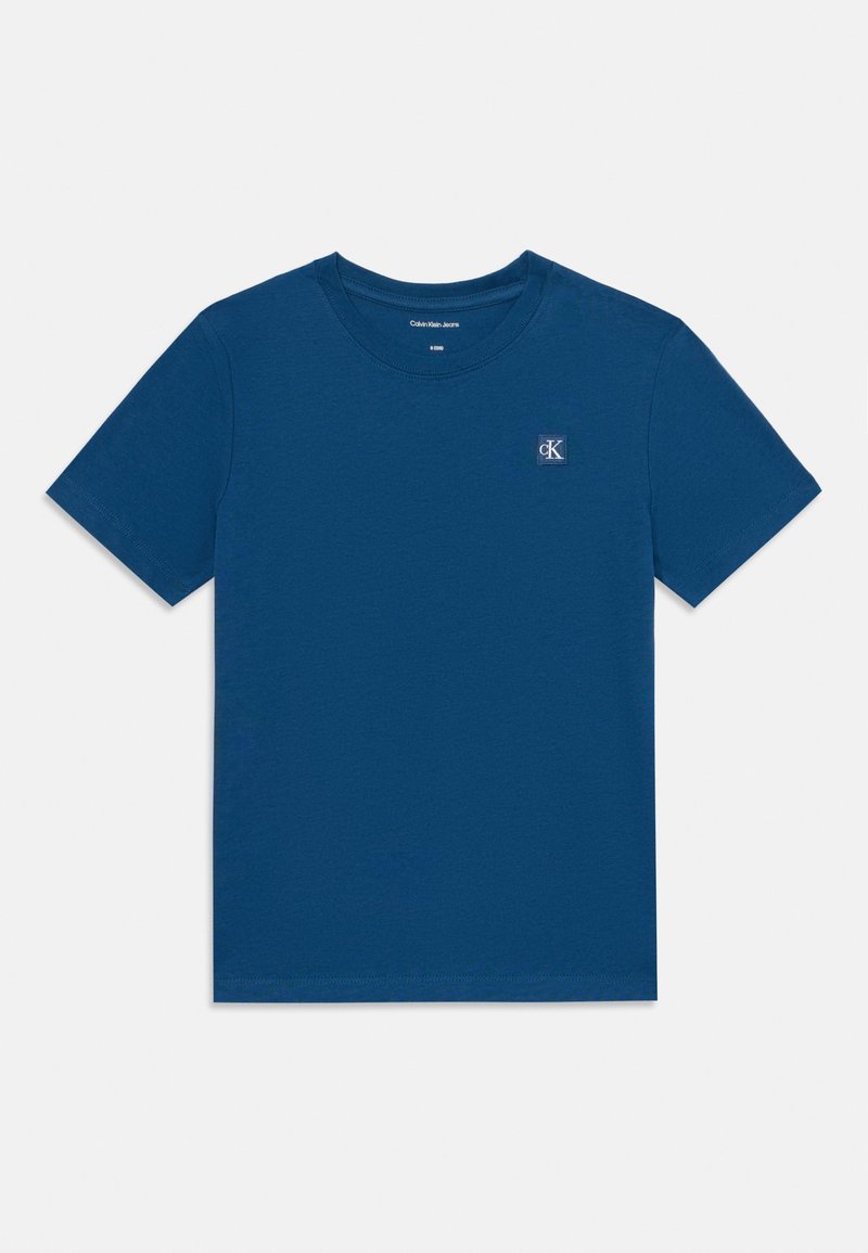 T-shirt in cotone blu con collo tondo, maniche corte e un piccolo logo CK sul lato sinistro in alto. Tessuto liscio e leggero.