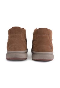 Brown suede ankle-height shoes with a solid tan sole and small logo detail embossed on the back. Features smooth texture and reinforced stitching.