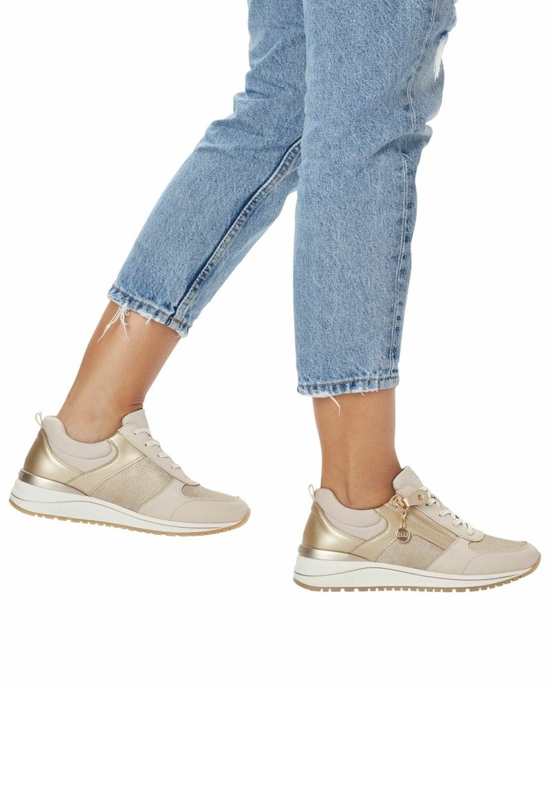 Sneakers beige e oro con tomaia in rete e sintetico, punta rotonda e suola texturizzata. Presentano un accento decorativo a zip e una suola intermedia bianca.