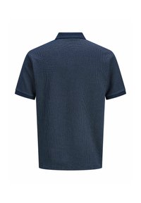 Polo bleu marine manches courtes avec un motif discret de petits pois, vu de dos.