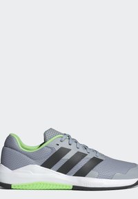 Chaussure de sport grise avec des rayures noires, doublure intérieure verte et semelle verte et blanche, vue de côté gauche sur un fond clair.