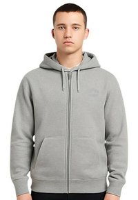 Sweat à capuche zippé gris en tissu doux, avec poche kangourou et capuche à cordon. Texture lisse avec poignets et ourlet côtelés.