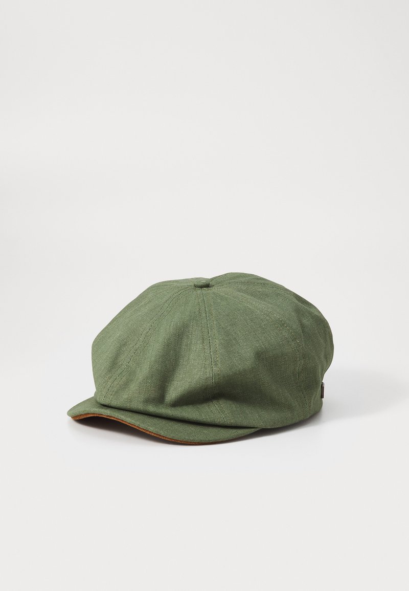 Casquette en chevrons verts avec une couronne ronde et un petit bord rigide. Présente un dessous marron sur le bord et de subtils détails de coutures.