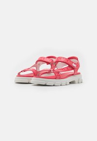Rosa synthetische Sandalen mit breiten Riemen, strukturiertem Obermaterial und einer weißen, robusten Sohle. Enthält Logo-Akzente und verstellbare Verschlüsse.