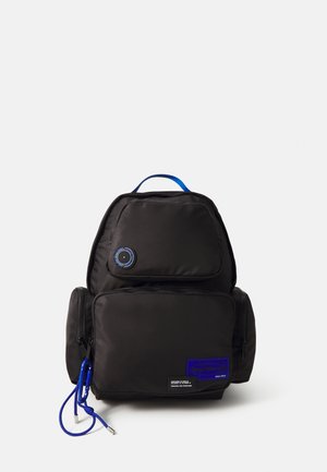 Schwarzer Rucksack aus Nylon, mit runder Form, einem blauen Hängeseil und einer Vordertasche mit einem blauen Etikett und kreisförmigen Akzenten.