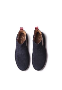Stivali alla caviglia in suede blu navy con pannelli laterali elasticizzati e linguette rosse. Fodera e suola in pelle. Taglia 37. Design minimale, texture morbida.