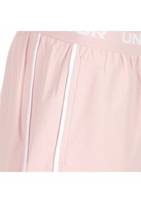 Shorts de sport roses avec un tissu texturé, des rayures blanches sur les côtés et une large ceinture élastique avec un marquage imprimé.