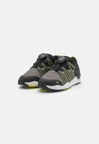 Black and gray athletic shoes with mesh upper, neon yellow accents, and adjustable fit system. Rubber outsole for traction.